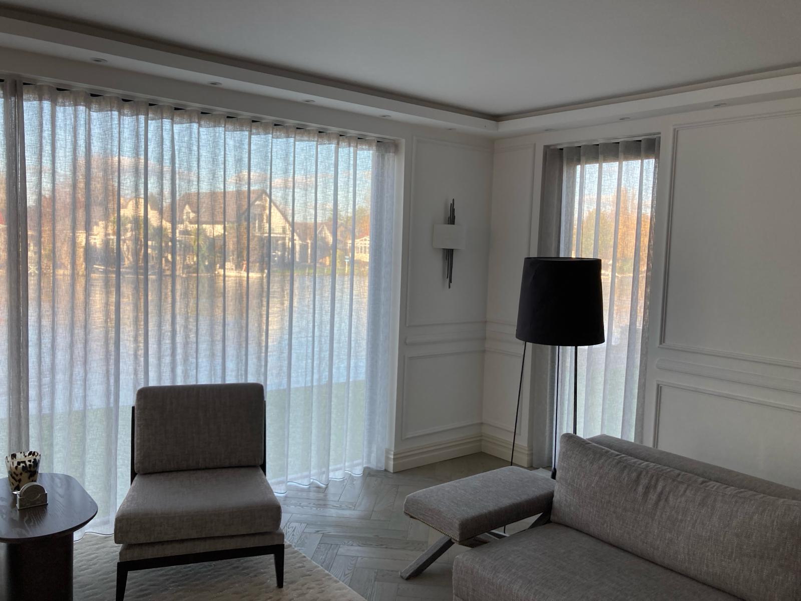 Wave-heading voile sheers across a panelled bay